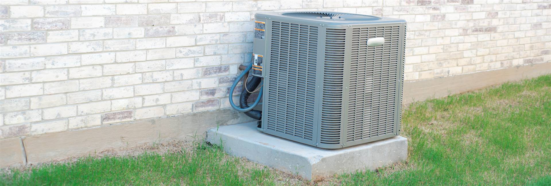 New air-source heat pump outdoor unit installed beside a Long Island, NY home